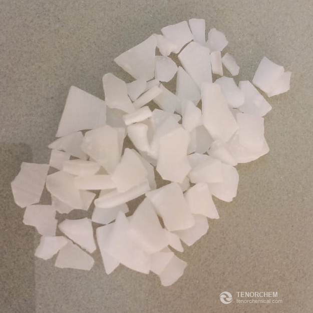 White aluminium sulfate flakes on a grey surface