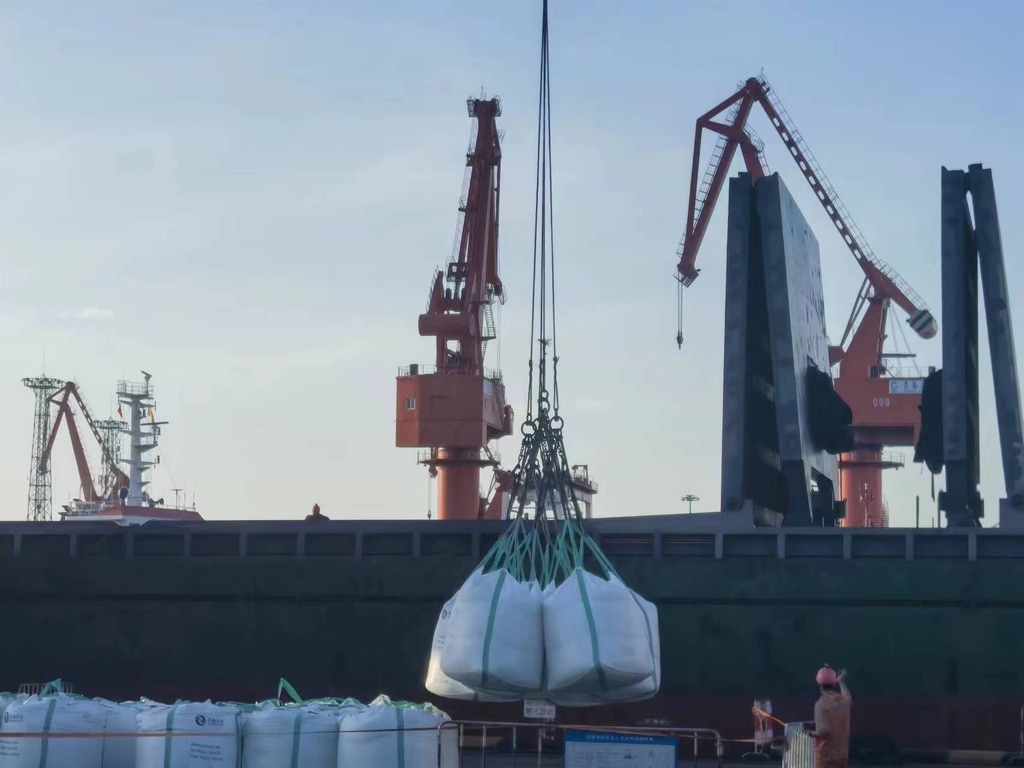 Calcium chloride big bags suspended from a port crane during vessel loading