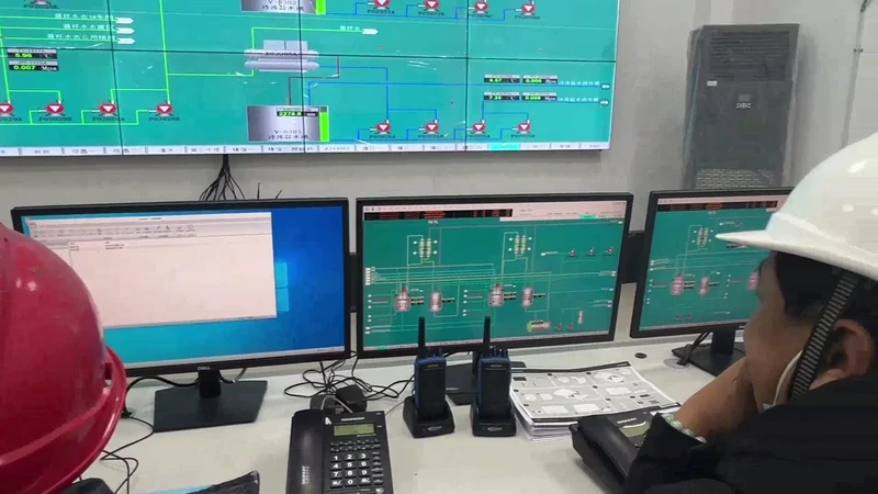 TENORCHEM staff at production control monitors in the company factory film