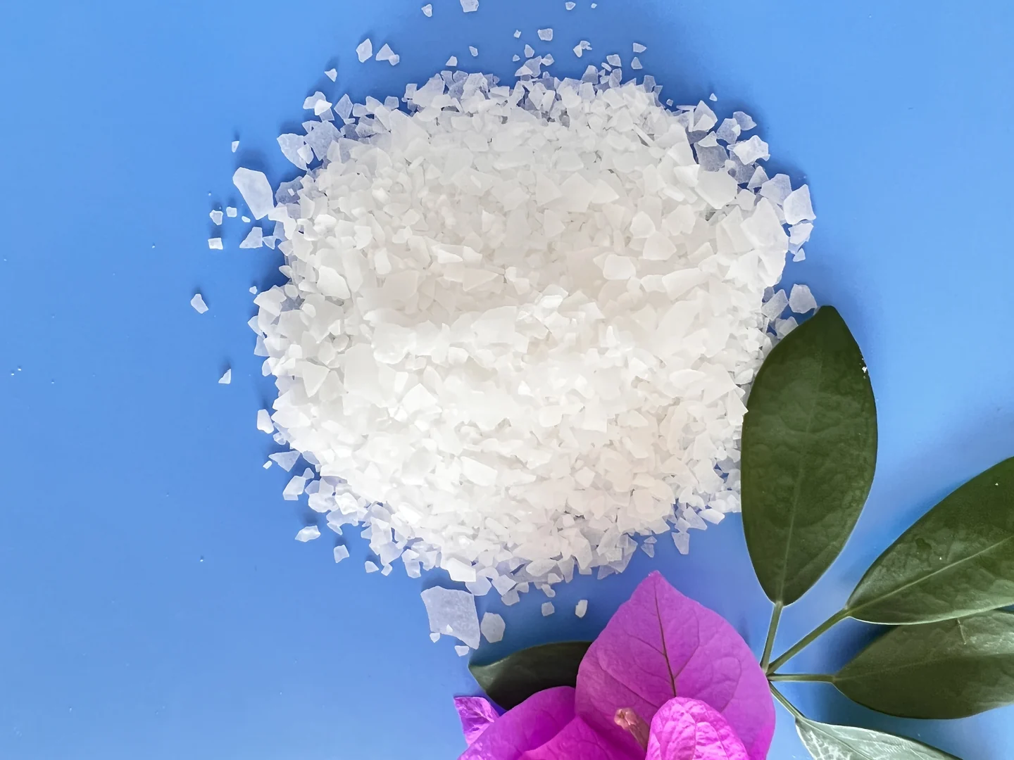 White magnesium chloride flakes photographed on a blue background