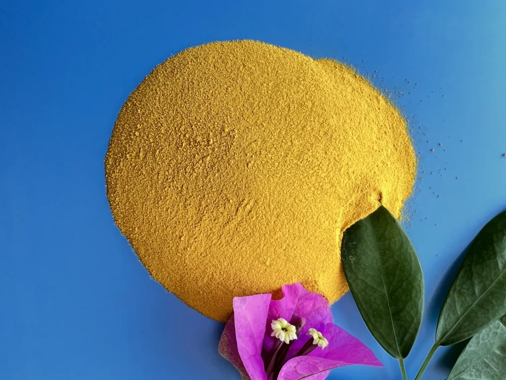 Yellow industrial PAC powder sample on a blue background